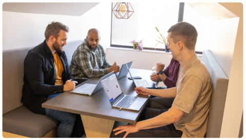 CloudM's implementation services team huddled in a meeting nook